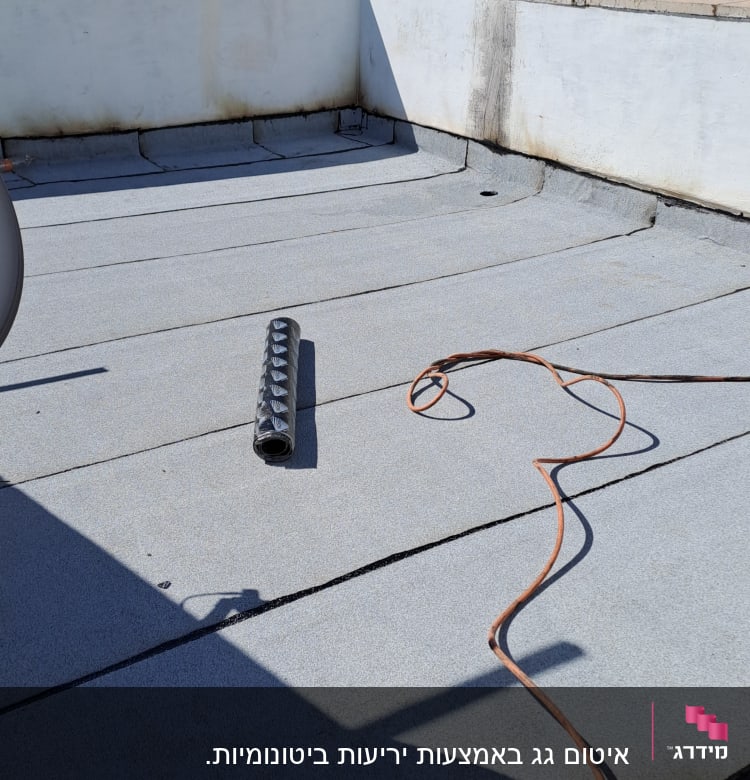 גג עם יריעות איטום, כבל חשמלי וגליל איטום